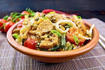 Image showing Noodles wok Thai in clay plate on dark board