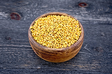 Image showing Fenugreek in clay bowl on wooden board