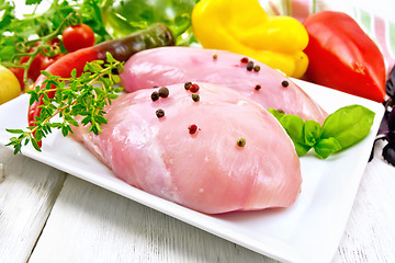 Image showing Chicken breast raw in plate with vegetables on table