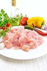 Image showing Chicken breast raw sliced in plate with vegetables on board