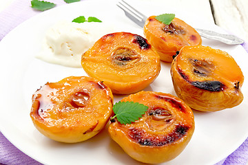 Image showing Quince baked with ice-cream in plate on lilac napkin