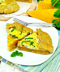 Image showing Pie of pumpkin and basil in plate on board