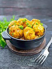 Image showing Meatballs in black brazier with greens on board