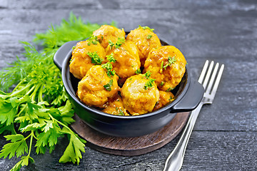 Image showing Meatballs in brazier on black board