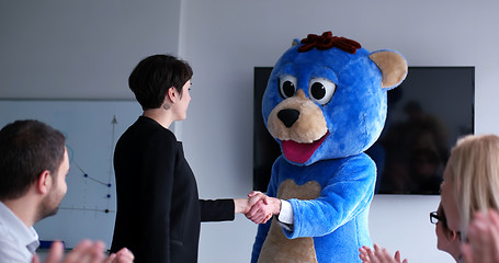 Image showing boss dresed as bear having fun with business people in trendy of