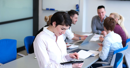 Image showing Businesswoman using tablet with coworkers in backgorund having m