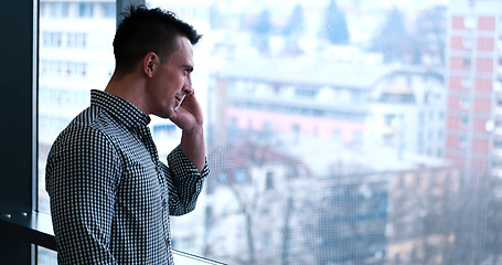 Image showing Business Man Talking On Cell Phone, Looking Out Office Window