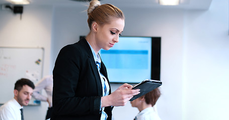 Image showing Businesswoman using tablet with coworkers in backgorund having m