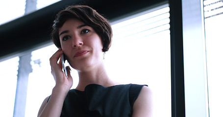 Image showing Business Girl Standing In A Modern Building Near The Window With