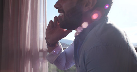 Image showing Business Man Talking On Cell Phone At Home