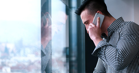 Image showing Business Man Talking On Cell Phone, Looking Out Office Window