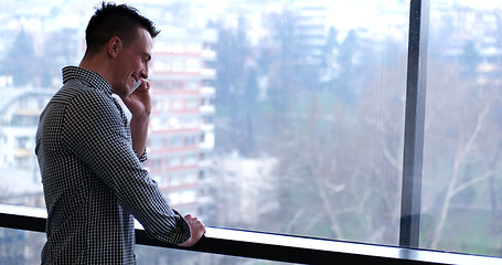 Image showing Business Man Talking On Cell Phone, Looking Out Office Window