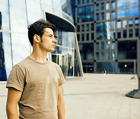 Image showing young handsome hipster guy outside infront of business building, lifestyle people concept