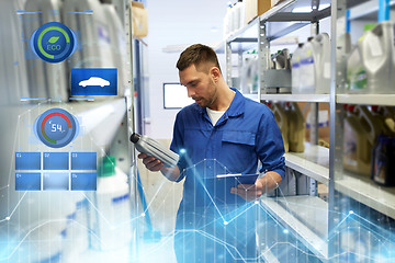 Image showing auto mechanic with oil and clipboard at car shop