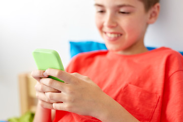 Image showing close up of happy boy with smartphone at home