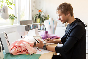 Image showing fashion designer with tablet pc working at studio