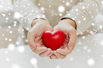 Image showing close up of senior man with red heart in hands