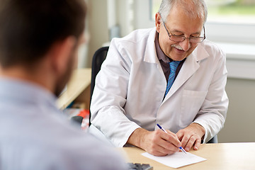 Image showing doctor writing prescription for patient at clinic