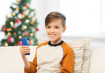 Image showing boy playing on smartphone at home at christmas