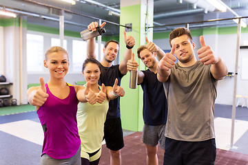 Image showing group of happy friends in gym showing thumbs up