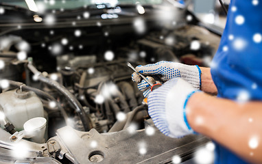 Image showing mechanic hands with wrench repairing car