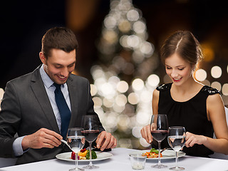 Image showing smiling couple eating at christmas restaurant