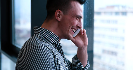 Image showing Business Man Talking On Cell Phone, Looking Out Office Window