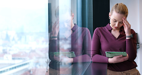 Image showing Pretty Businesswoman Using Tablet In Office Building by window