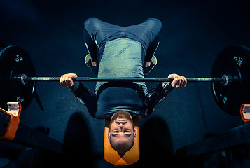 Image showing Portrait of super fit muscular young man working out in gym with barbell