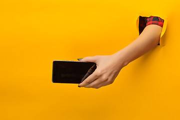 Image showing female teen hands using phone with black screen, isolated