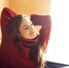 Image showing young pretty real woman in red sweater and scarf all over her fa