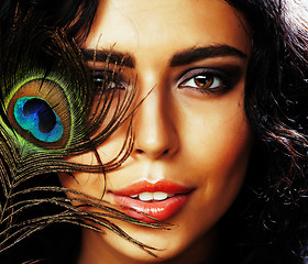 Image showing young sensitive brunette woman with peacock feather eyes close up on green smiling, lifestyle people concept macro