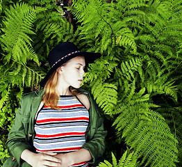 Image showing Pretty young blond girl hipster in hat among fern, vacation in green forest, lifestyle fashion people concept 