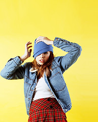 Image showing lifestyle people concept: pretty young school teenage girl having fun happy smiling on yellow background 