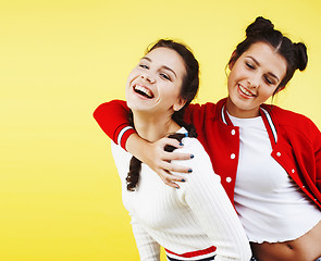 Image showing lifestyle people concept: two pretty young school teenage girls having fun happy smiling on yellow background