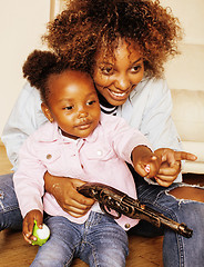 Image showing adorable sweet young afro-american mother with cute little daughter, hanging at home, having fun playing smiling, lifestyle people concept, happy smiling modern family 