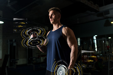 Image showing young man with dumbbells exercising in gym