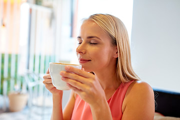 Image showing close up of woman drinking coffee at restaurant