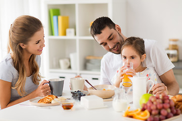 Image showing happy family having breakfast at home