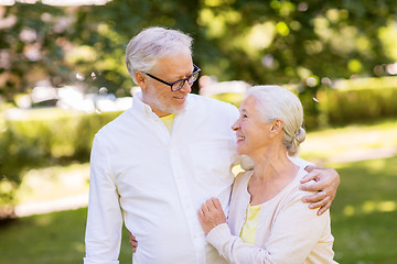 Image showing happy senior couple hugging at summer park