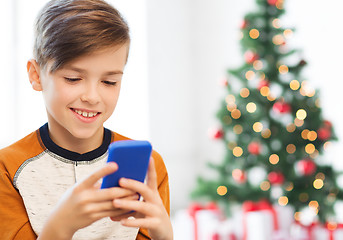 Image showing close up of happy boy with smartphone at christmas