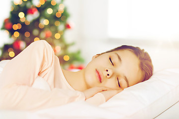 Image showing girl sleeping in bed over christmas tree 