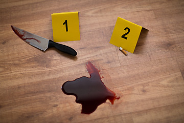 Image showing knife in blood and evidence marker at crime scene