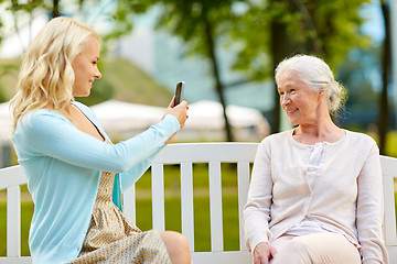 Image showing daughter photographing senior mother by smartphone