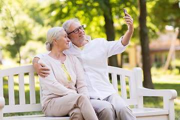 Image showing senior couple taking selfie by smartphone at park