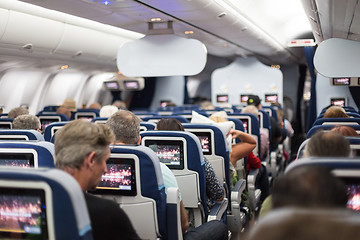 Image showing Interior of large commercial airplane with passengers on seats waiting to taik off.