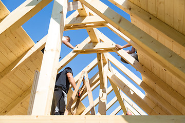 Image showing Builders at work with wooden roof construction.