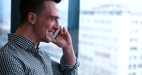 Image showing Business Man Talking On Cell Phone, Looking Out Office Window