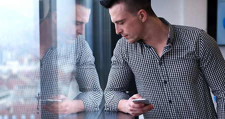 Image showing Business Man Talking On Cell Phone, Looking Out Office Window