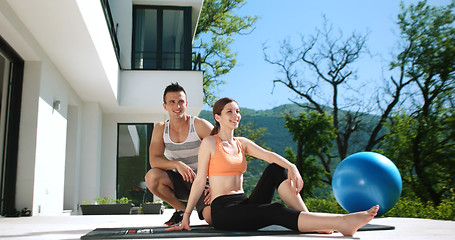 Image showing Couple Doing Stretching Exercises Together in front of luxury vi